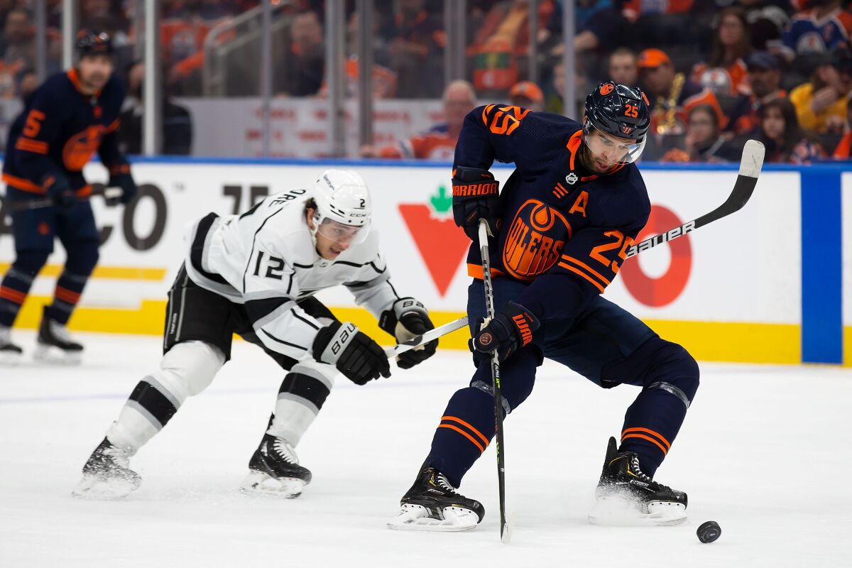The Oilers Darnell Nurse (25) and the Kings' Trevor Moore compete for the puck in Game 5. 