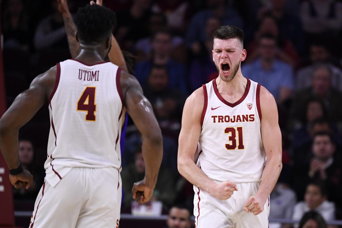 USC forward Nick Rakocevic, right, celebrates with guard Daniel Utomi after scoring and drawing a foul during the second half against Washington on Feb. 13 at Galen Center.
