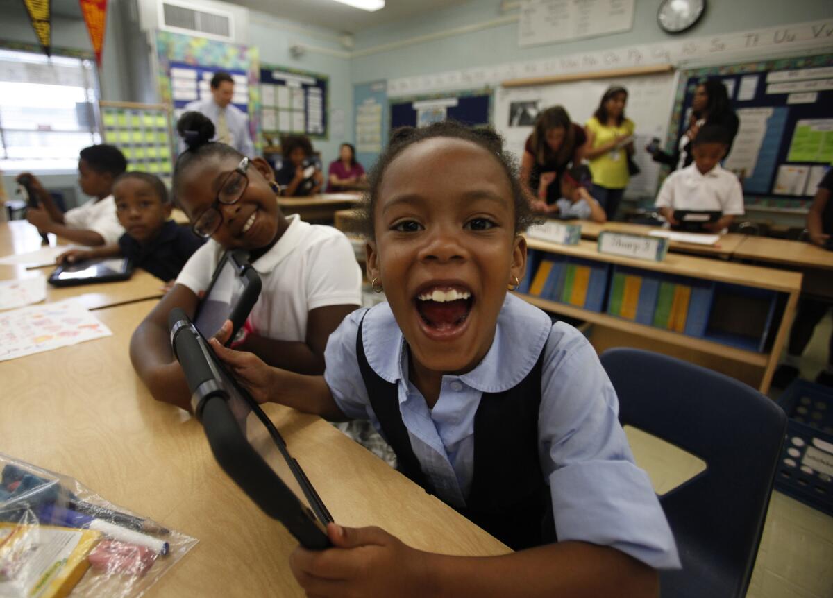 Tiannah Dizadare smiles as she and a school mate explore the possibilities with their new LAUSD provided IPads.