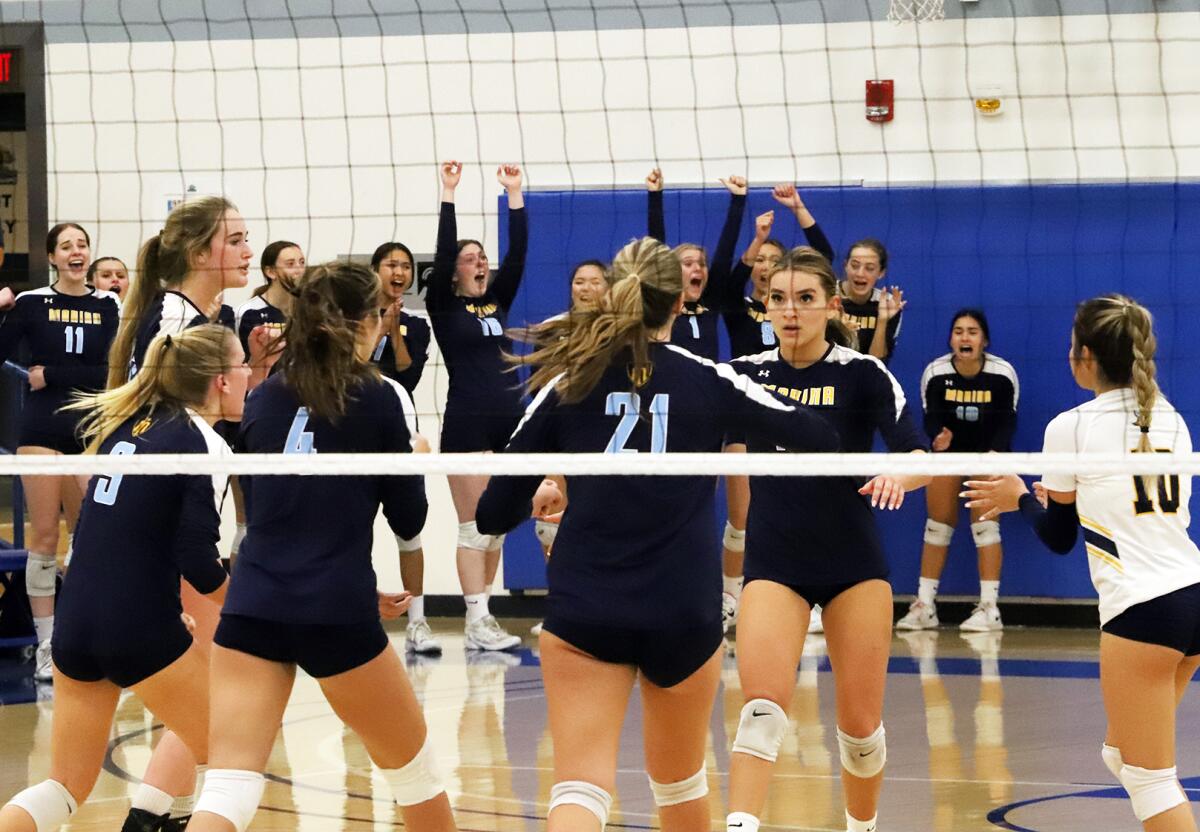 The Marina girls' volleyball team celebrates scoring in the CIF Southern Section Division 5 final at Cerritos College.