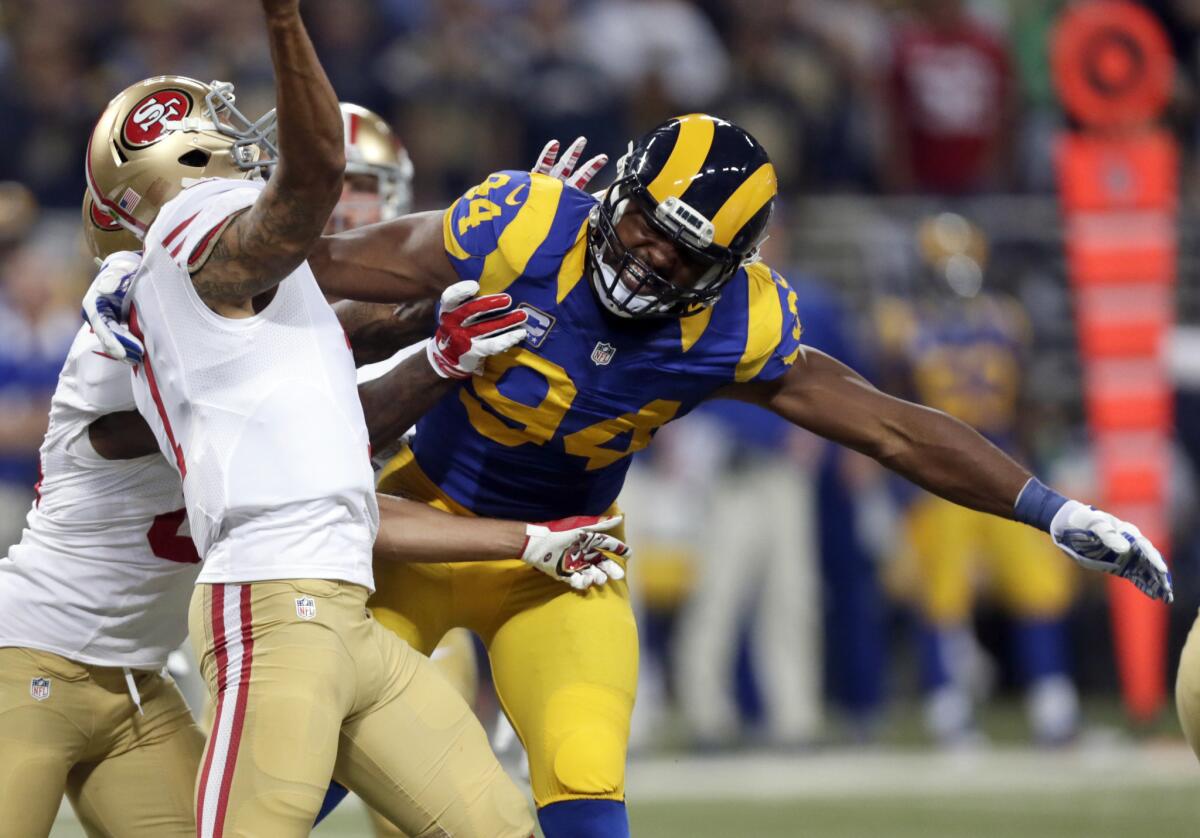San Francisco quarterback Colin Kaepernick, left, throws under pressure from Rams defensive end Robert Quinn during the first quarter of a game on Nov. 1.