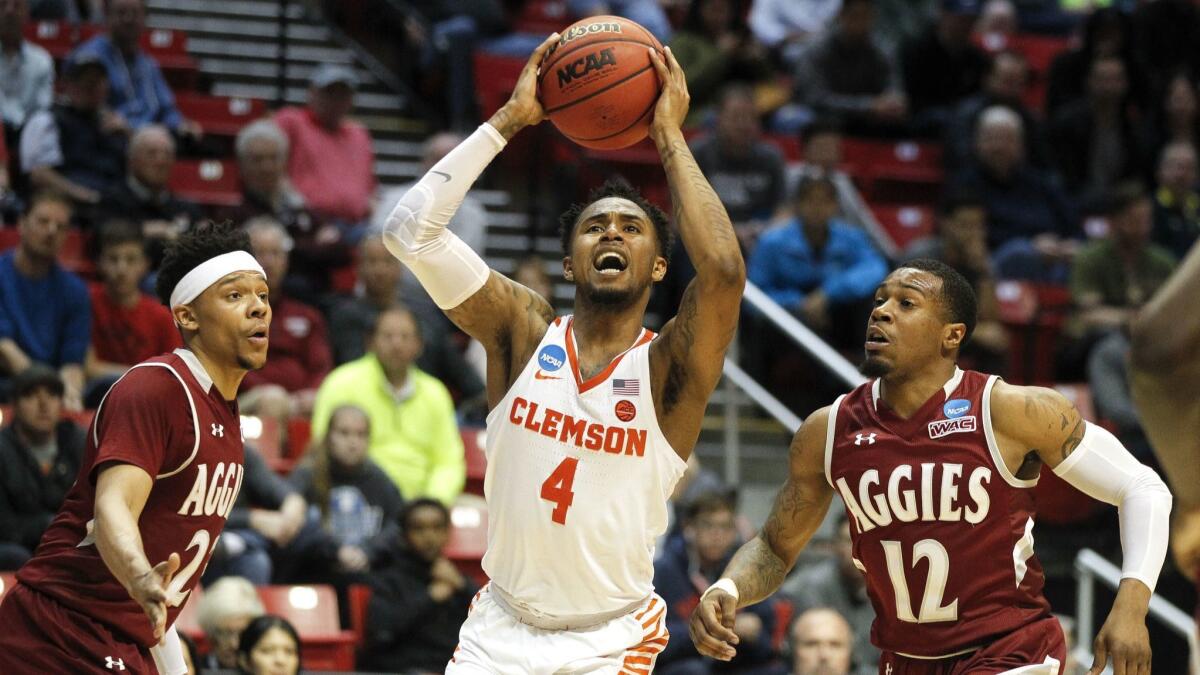 Clemson's Shelton Mitchell shoots while pressured by New Mexico State's Zach Lofton, left, and AJ Harris in the second half during the first round of the NCAA tournament.