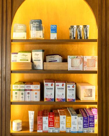 Marijuana products on display in shelves in an archway-shaped alcove at Green Goddess.