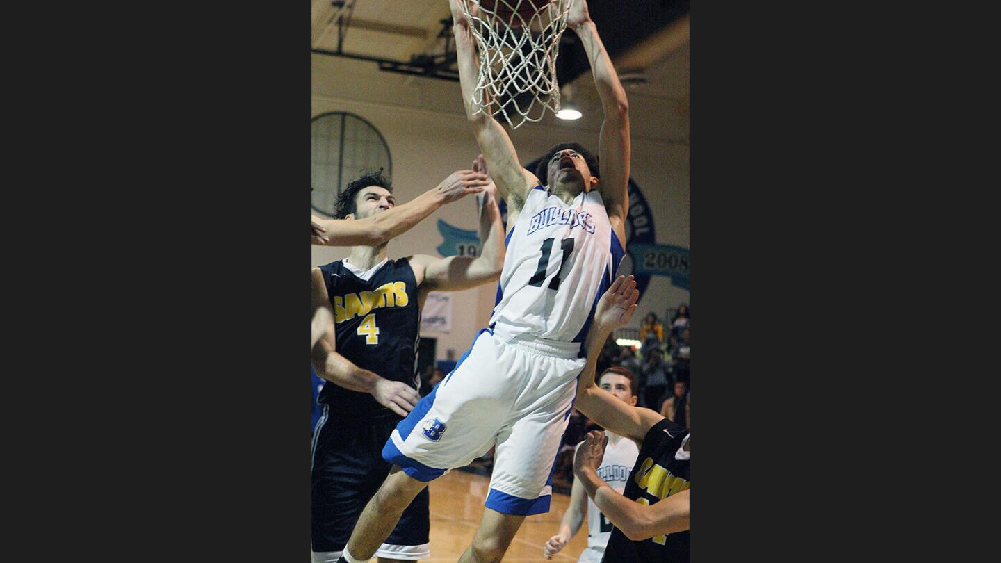 Burbank's Michael Woods, with the winning shot rolling off of the rim, grabs the ball and dunks it in the final second of the game for the win over Crean Lutheran in a CIF Southern Section CIF quarterfinal playoff boys' basketball game at Burbank High School on Tuesday, February 21, 2017.