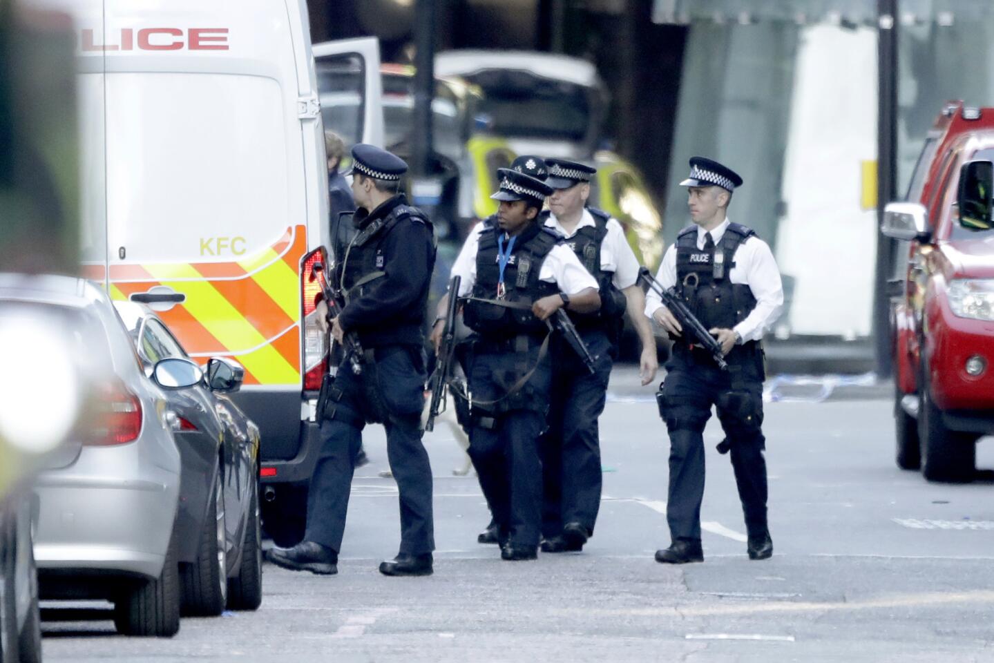 Armed British police work within a cordoned-off area Sunday after the London Bridge attack.
