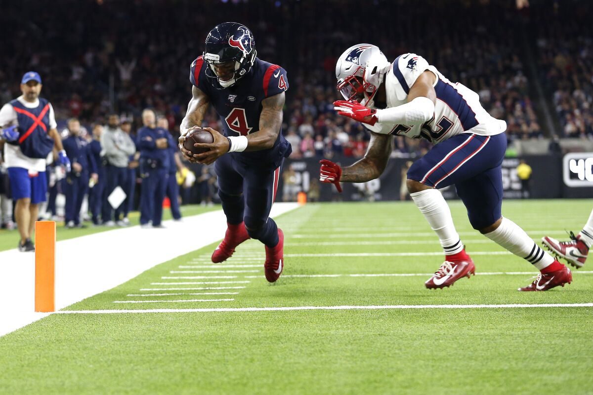 Houston Texans quarterback Deshaun Watson scores a touchdown in front of New England Patriots linebacker Elandon Roberts.