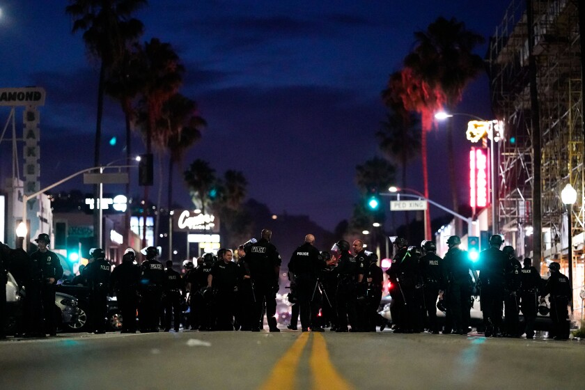 Police gather Saturday night the Fairfax District, with Canter’s Deli in the background.