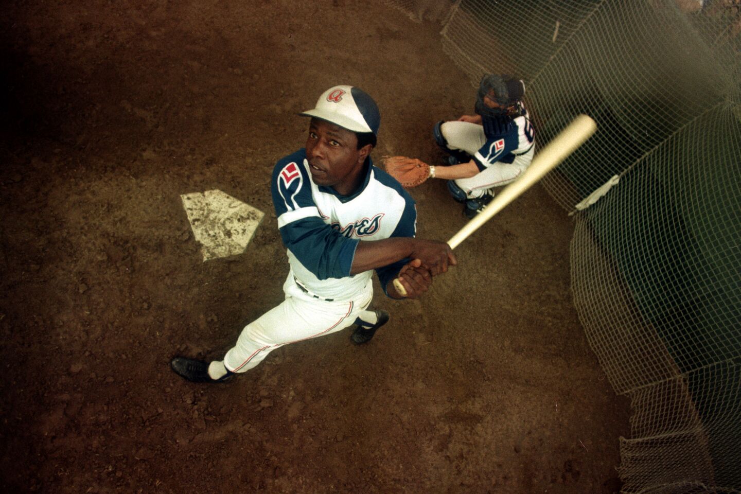 Atlanta Braves outfielder Hank Aaron swings a bat at home plate during spring training
