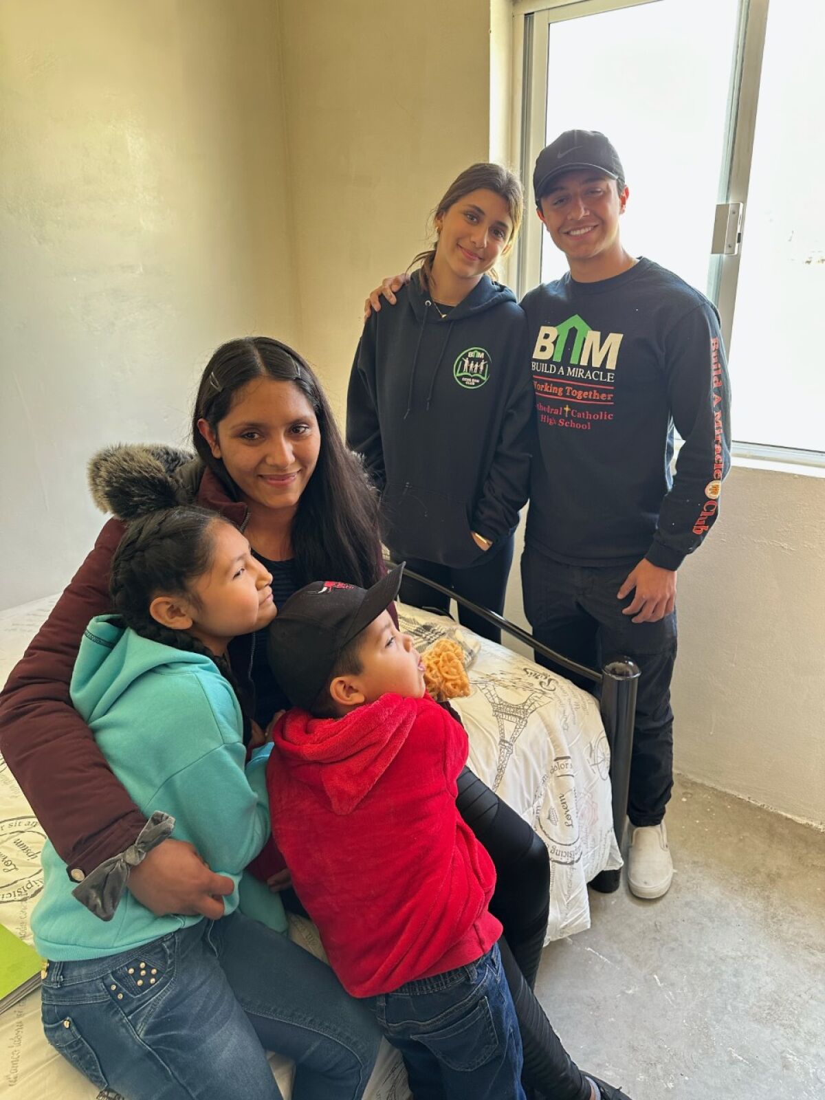 Ava Simone and Gabriel Benitez (right) with the the mother and her two children for whom they built the home.