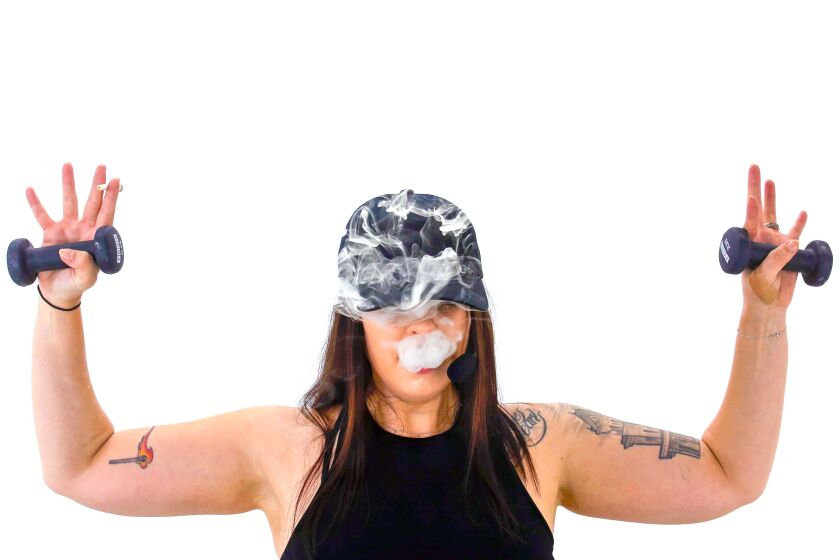 A person holding two weights up also smoking a marijuana joint.