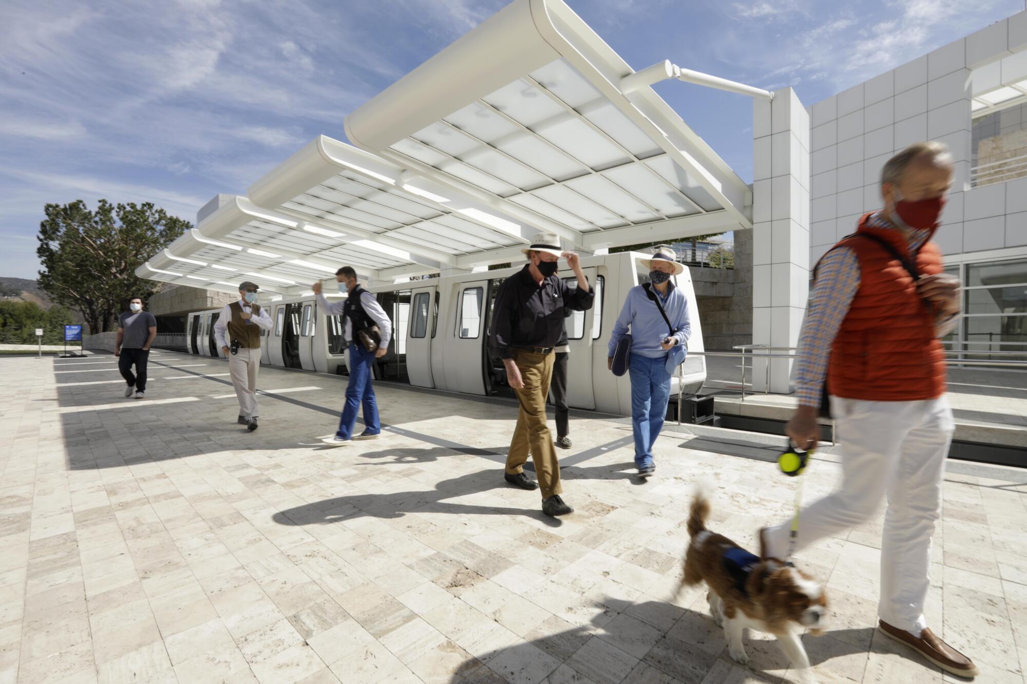 People walk toward the Getty entrance from the tram terminus