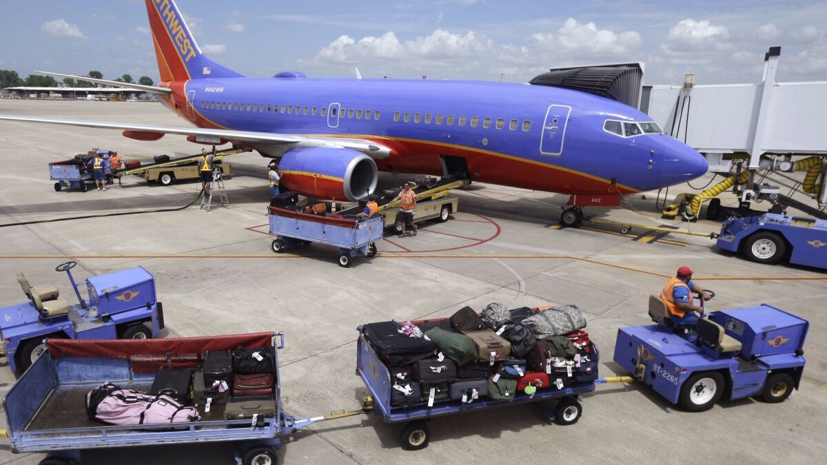 Baggage carts are towed to a Southwest Airlines jet at Bill and Hillary Clinton National Airport in Little Rock, Ark. Southwest Airlines reported its 44th straight year of profitability last year.
