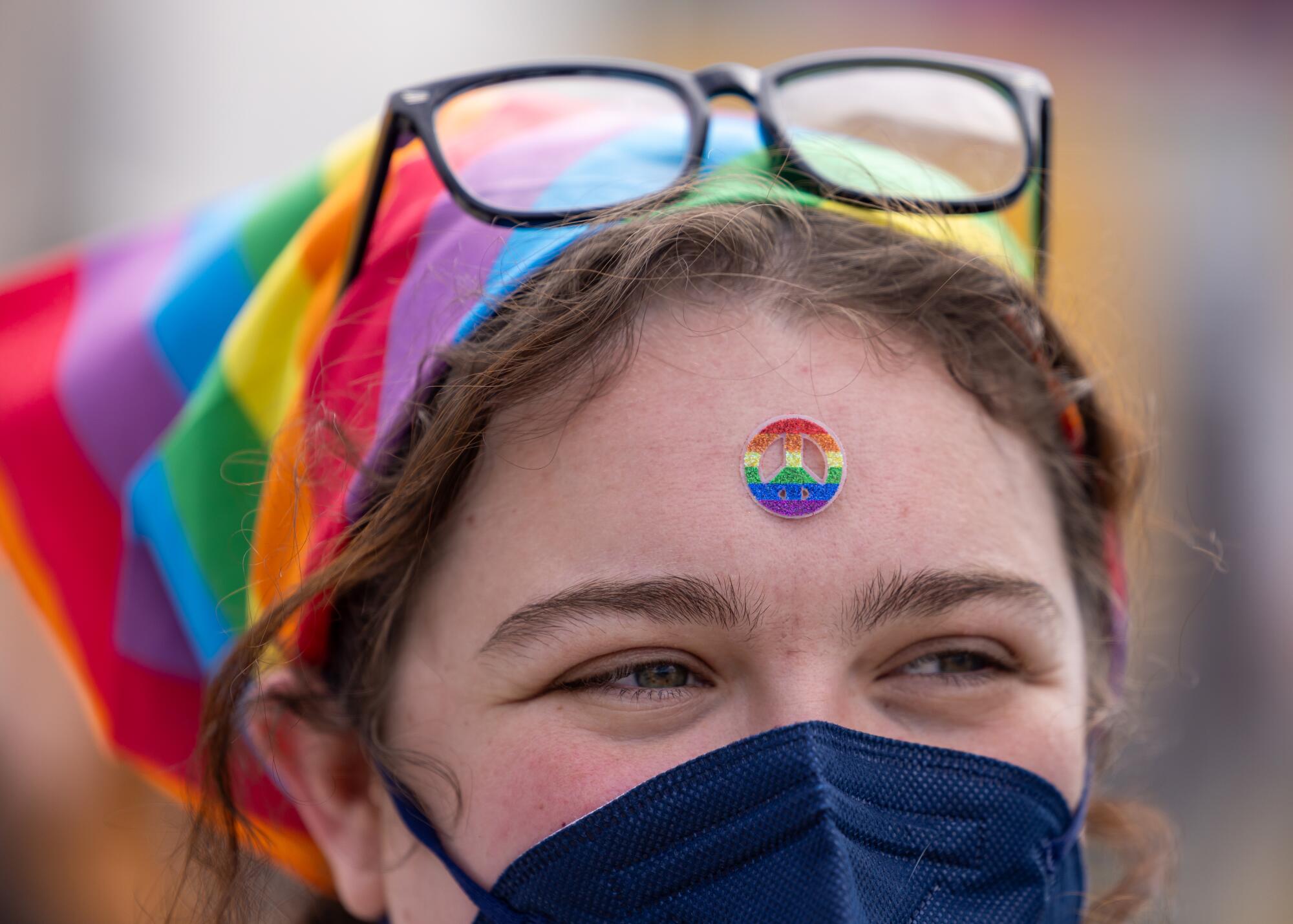 A protester wears a rainbow peace sign while joining a demonstration in Los Angeles in March.