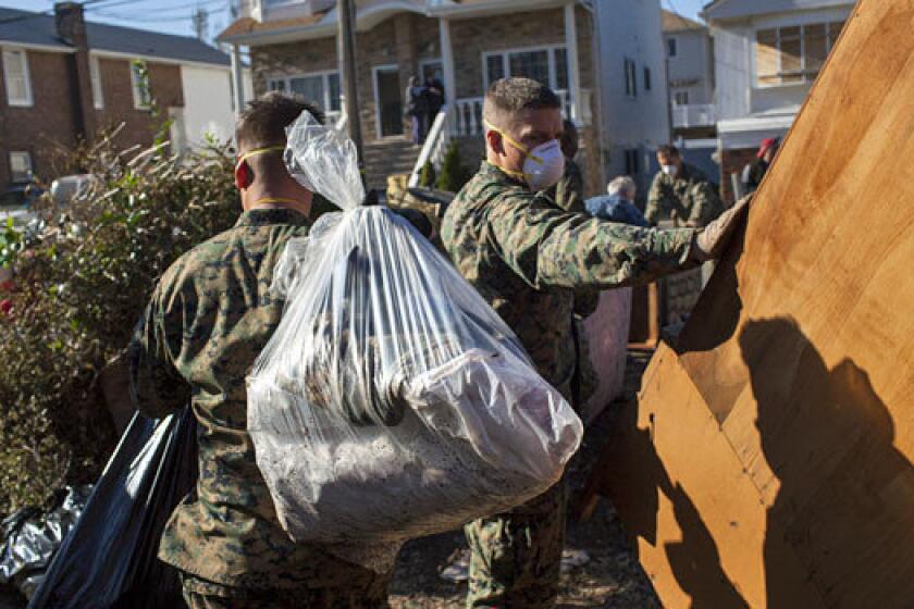 Marines from the 26th Marine Expeditionary Unit and U.S. Navy seamen offer assistance to local residents removing household items damaged by Superstorm Sandy on Staten Island, N.Y.