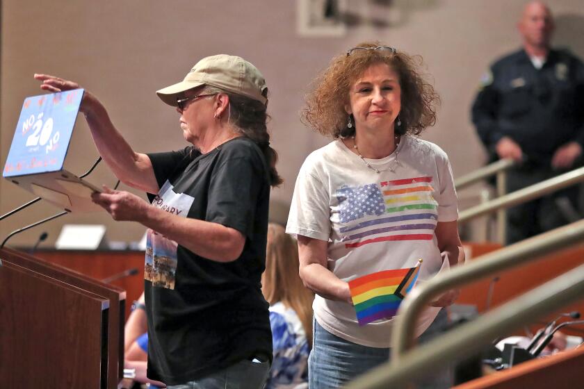 Public commentators Ms. Lingan and Libby Frolichman, from left, express thier concerns at the podium over new possible ordinances during vocal Huntington Beach City Council meeting on Tuesday.