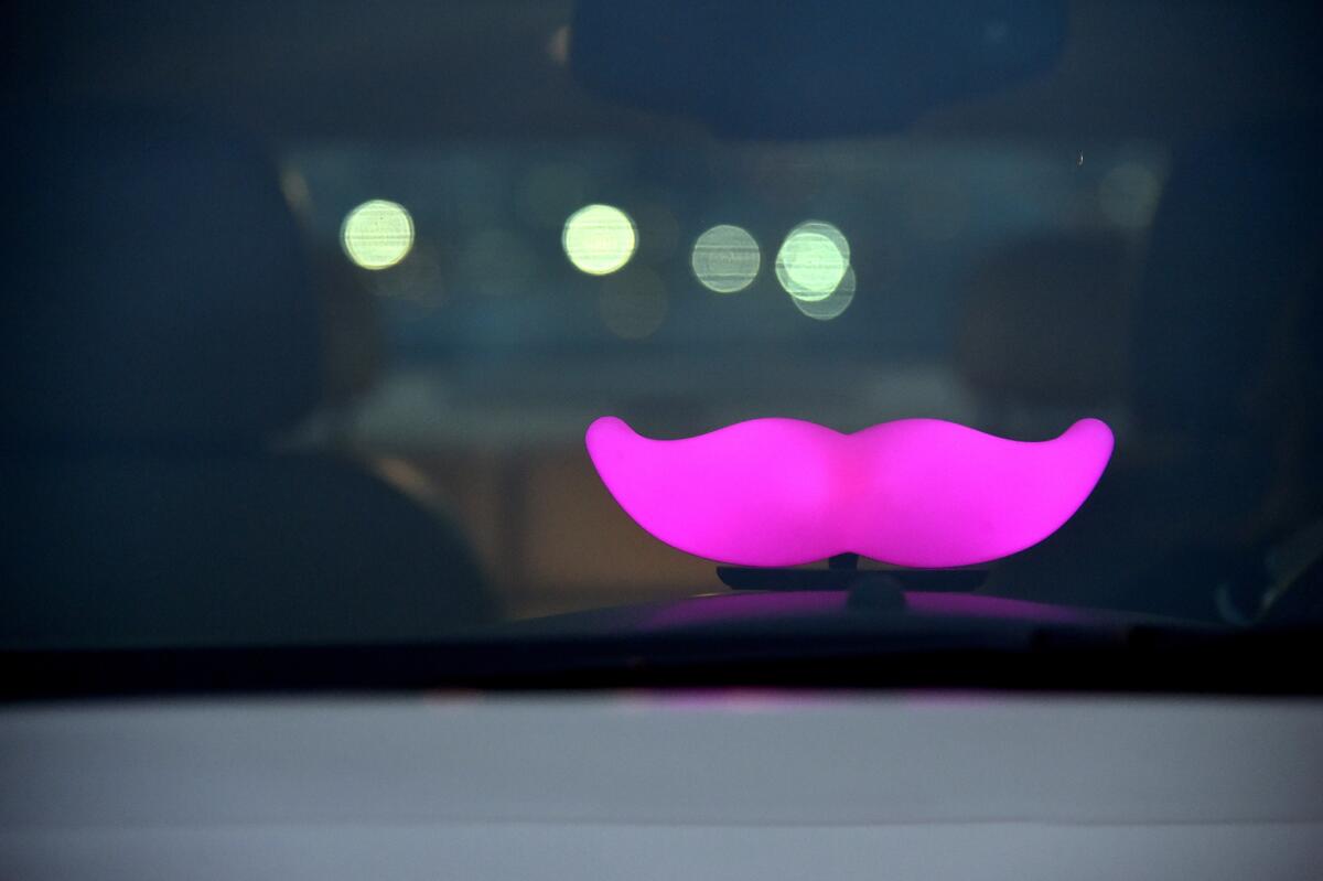 A dashboard logo identifies a car as driving for Lyft.