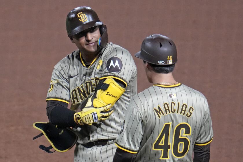 El colombiano de los Padres de San Diego, Donovan Solano (izquierda), se coloca en la primera base luego de impulsar dos carreras con un sencillo ante los Piratas de Pittsburgh durante el novoeno episodio del juego de béisbol en Pittsburgh, el martes 6 de agosto de 2024. (AP Foto/Gene J. Puskar)