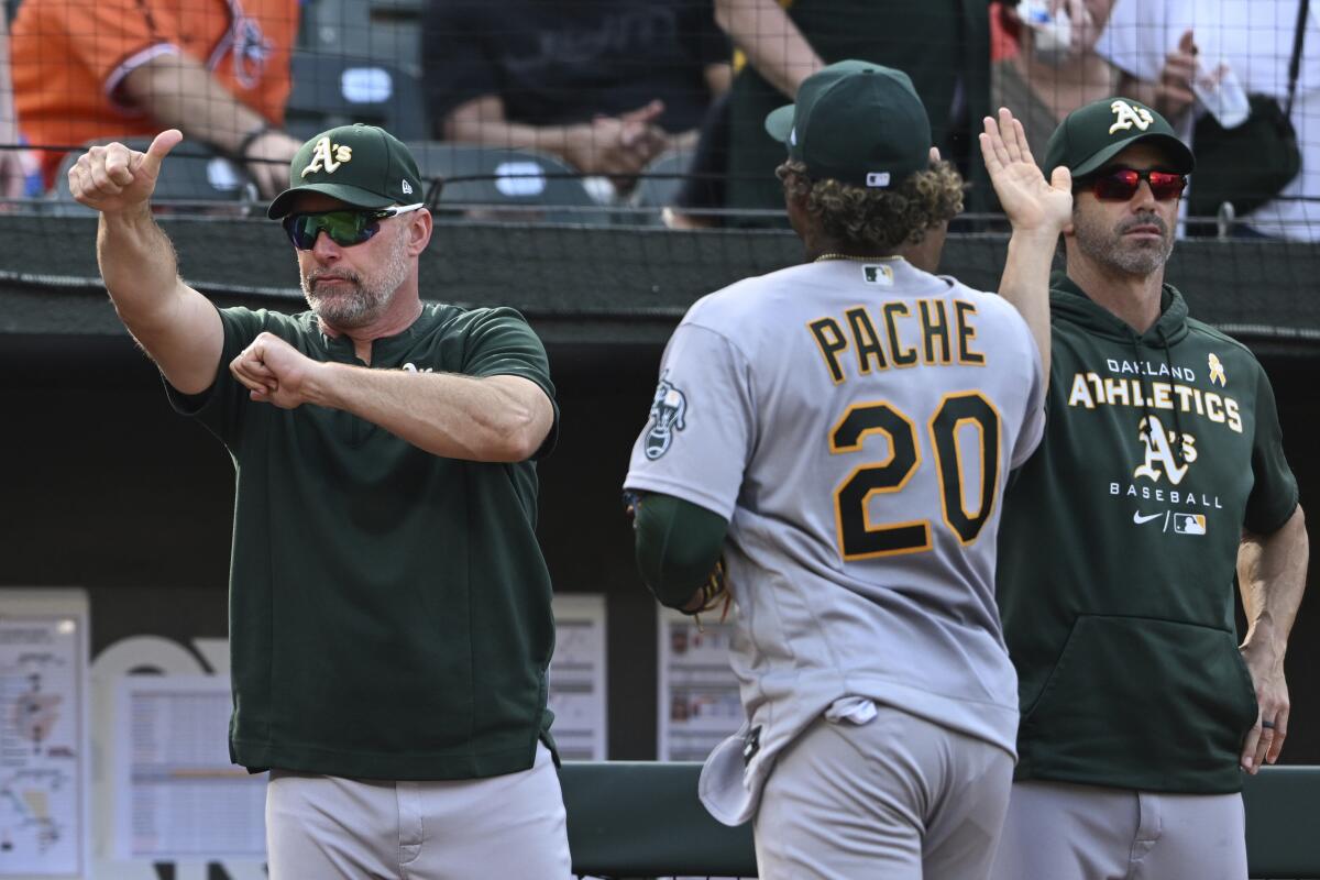 Oakland Athletics manager Mark Kotsay, left, gives a thumbs-up after defeating the Baltimore Orioles in a baseball game, Sunday, Sept. 4, 2022, in Baltimore. (AP Photo/Gail Burton)