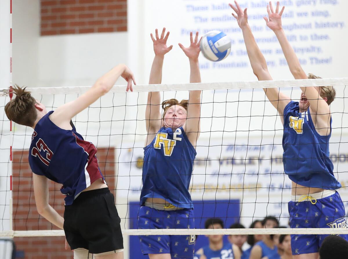 Fountain Valley's Bryant Johnson (2) and Billy Watkins (11) block Capistrano Valley Christian's Blake Sheveland (13).