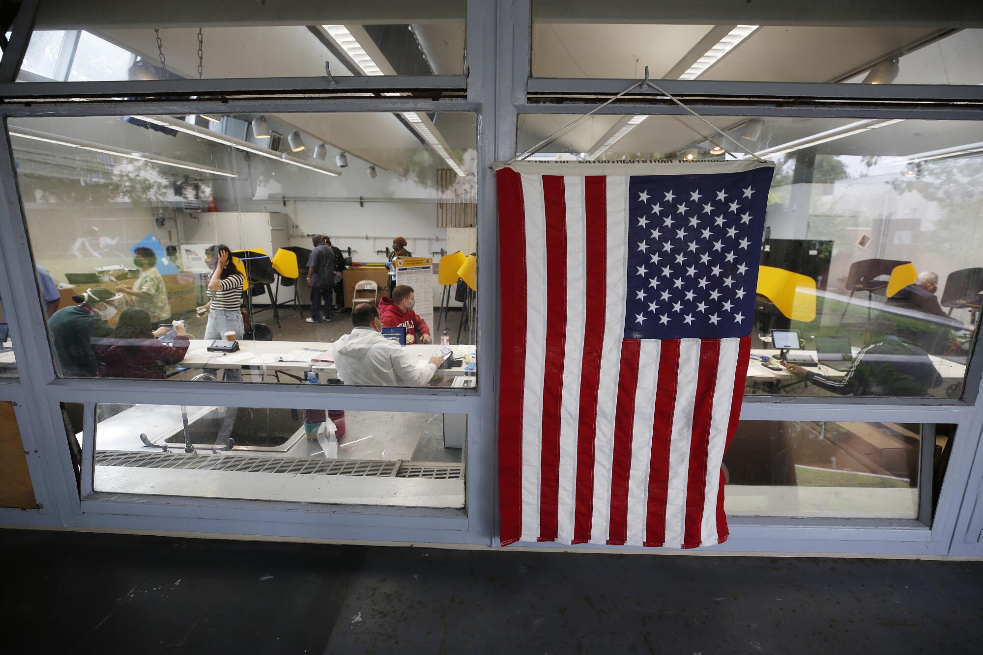 An American flag hangs in the window of a vote center