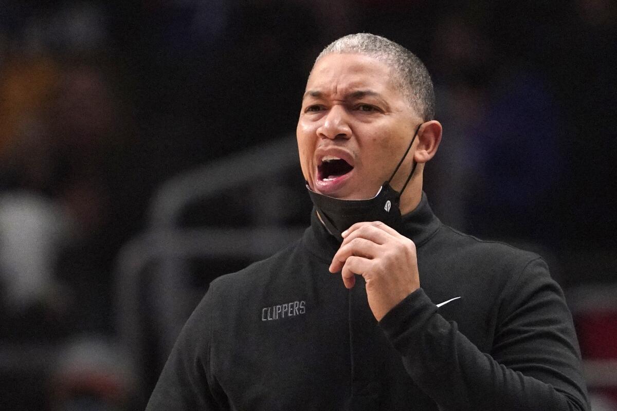 Clippers coach Tyronn Lue pulls down his mask and yells to his players during a game against the Memphis Grizzlies.