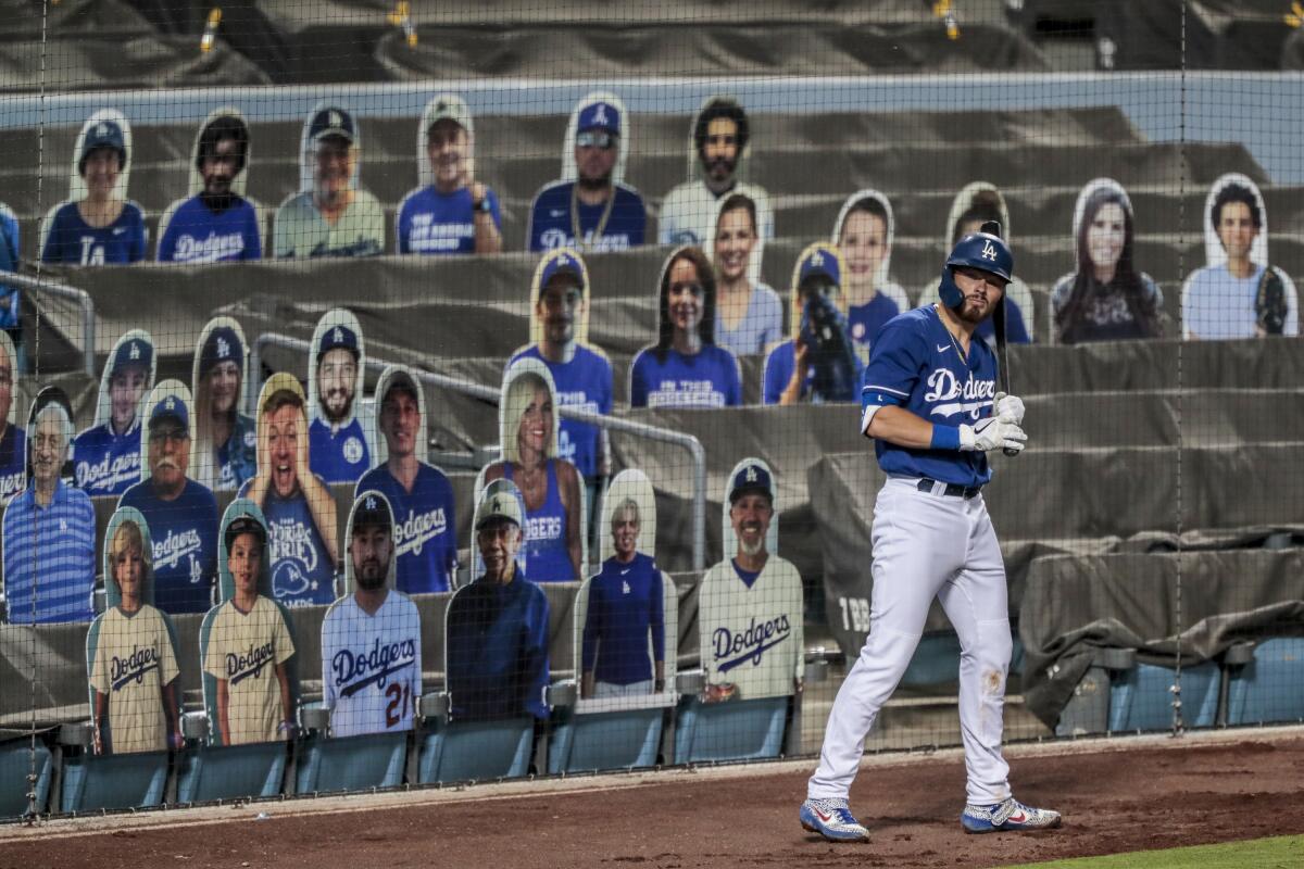 Dodgers second baseman Gavin Lux gets ready in the on-deck circle in front of cardboard cutouts of fans.