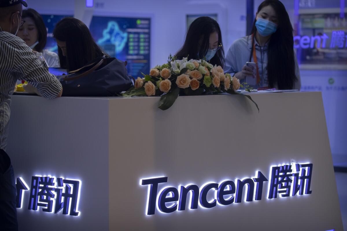Visitors gather at a display booth for Chinese technology firm Tencent. 