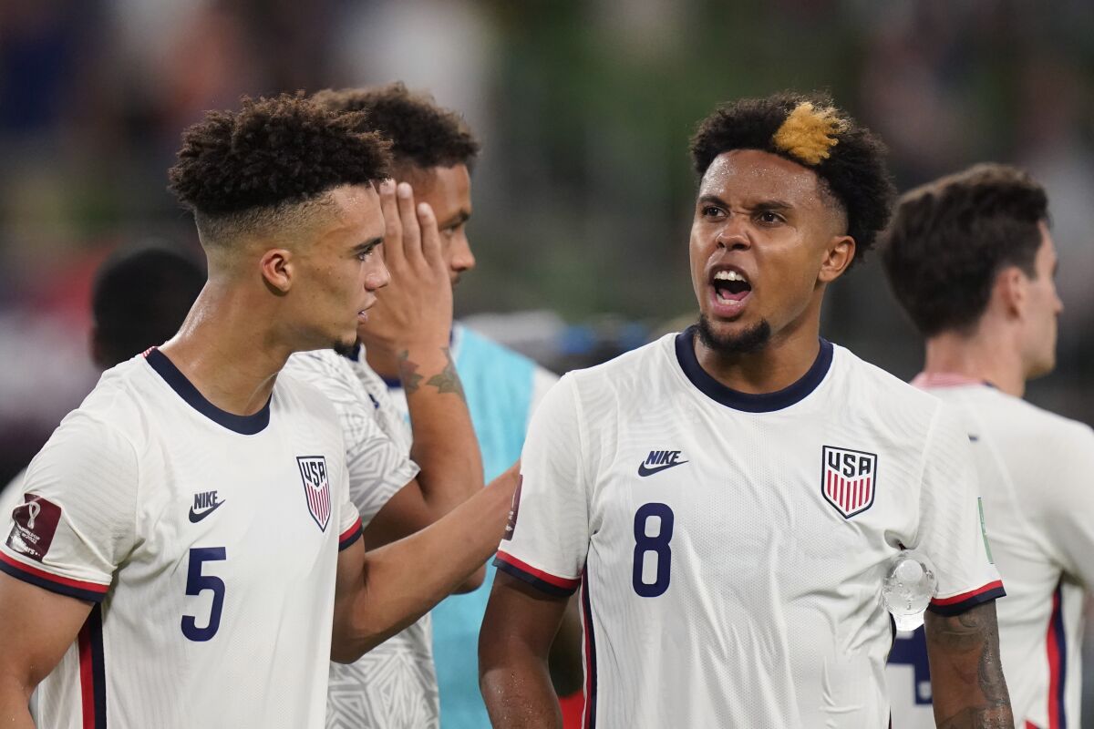 United States' Antonee Robinson (5) and Weston McKennie (8) celebrate with fans after their win over Jamaica in a FIFA World Cup qualifying soccer match, Thursday, Oct. 7, 2021, in Austin, Texas. (AP Photo/Eric Gay)