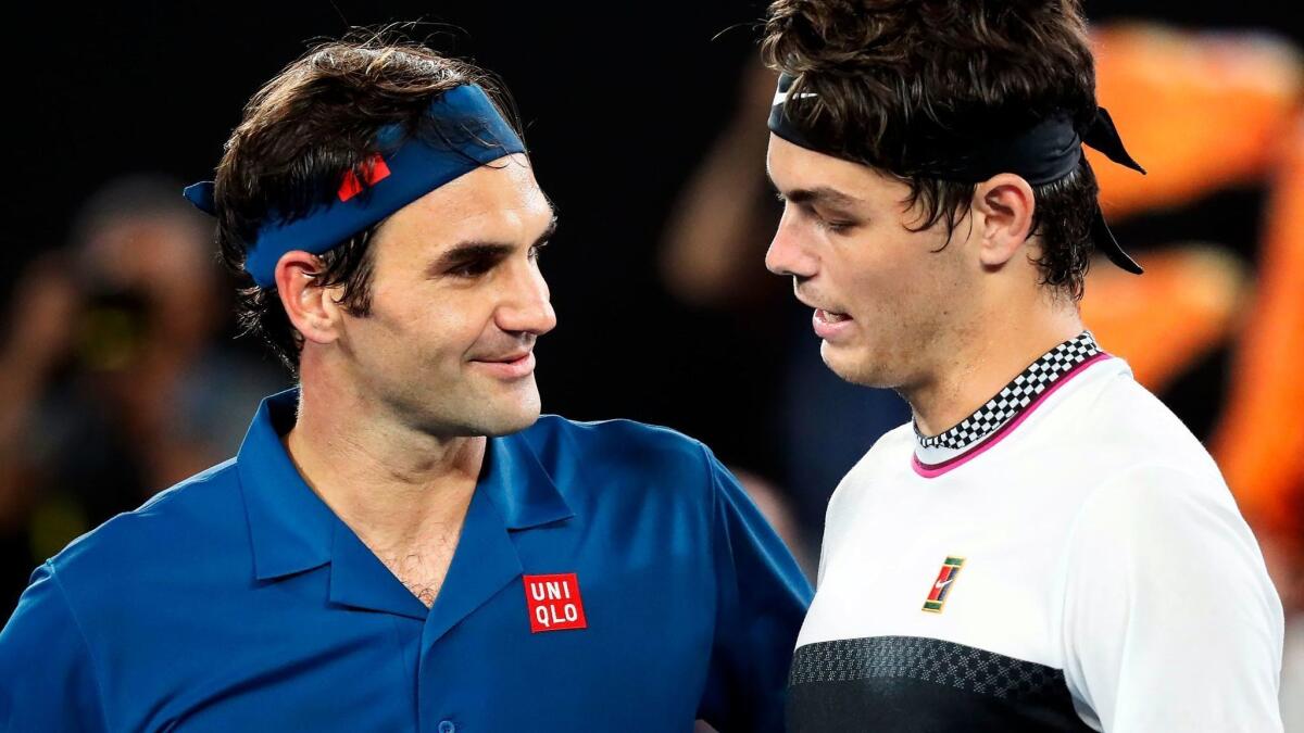 Roger Federer speaks with Taylor Fritz of during their men's singles match at the Australian Open.