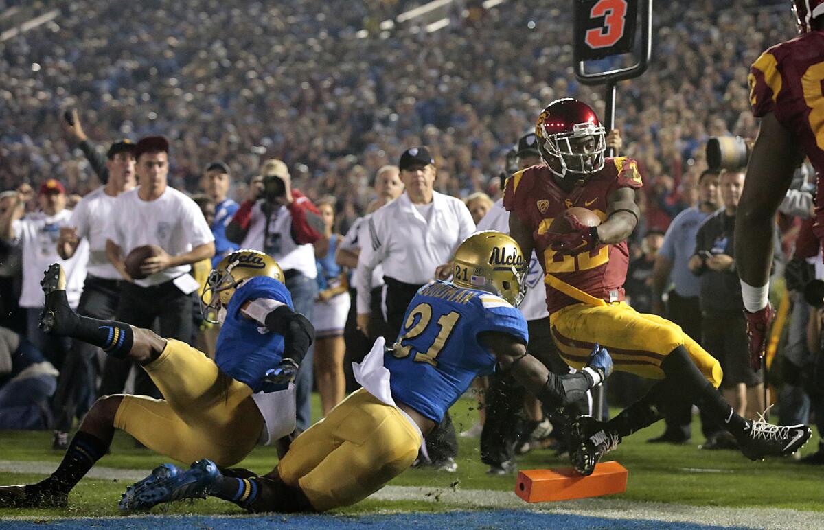 USC's Justin Davis rushes past UCLA's Tahaan Goodman on Nov. 22, 2014.