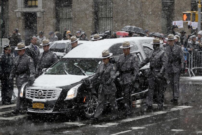 A hearse carrying the body of former New York Gov. Mario Cuomo is flanked by state troopers during his funeral at Church of St. Ignatius Loyola in New York. Cuomo, 82, died in his Manhattan home on Jan. 1, hours after his son Gov. Andrew Cuomo was inaugurated for a second term.