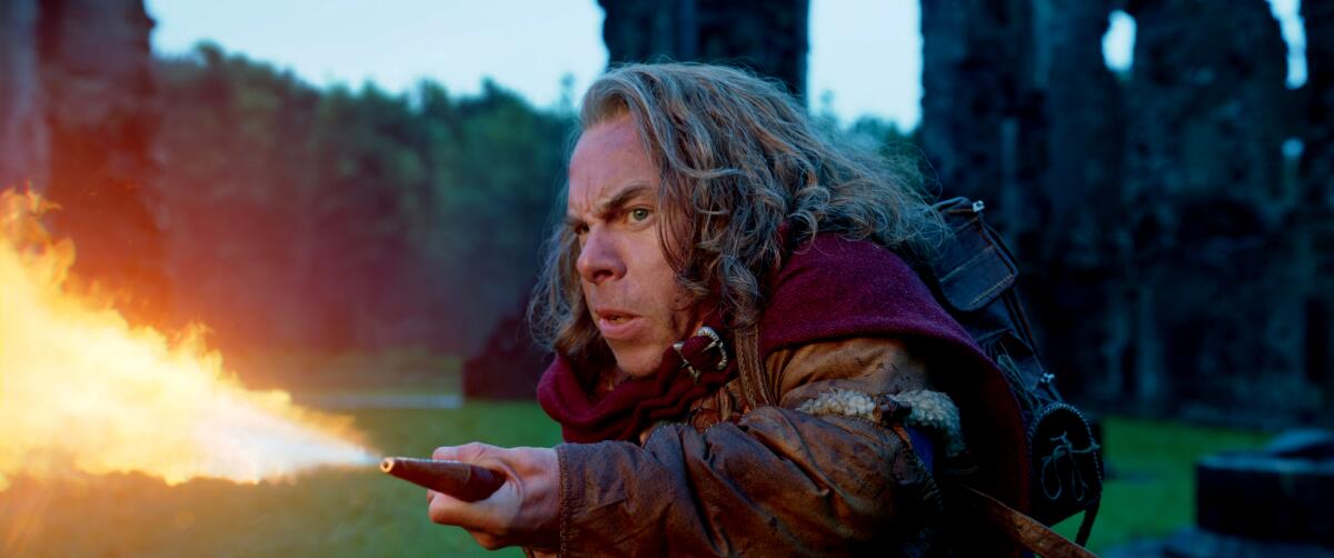 An actor wields a wand that is shooting fire