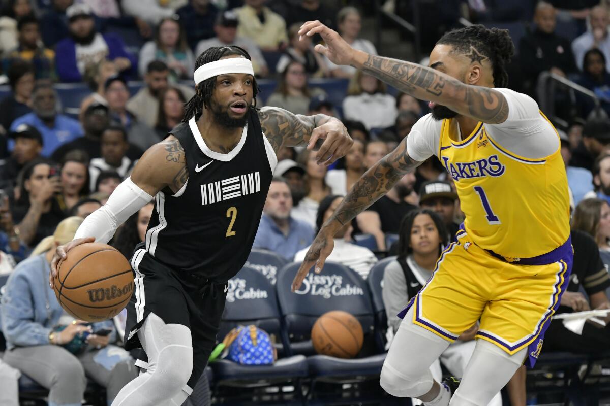 Lakers guard D'Angelo Russell tries to cut off a drive by Grizzlies guard Zavier Simpson on Friday night in Memphis.