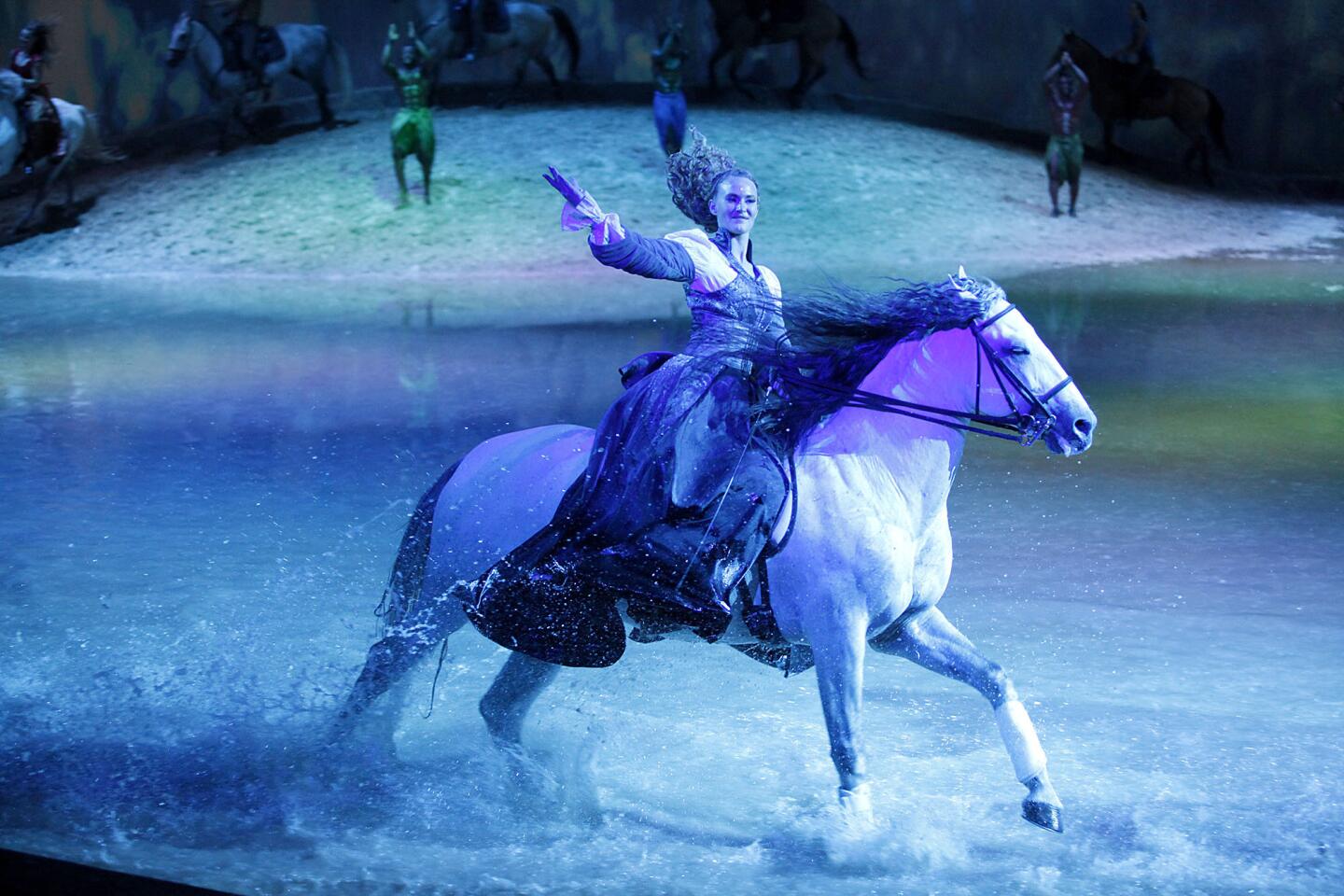 Performer and horse trainer Elise Verdoncq waves goodbuye to the crowds as she and her horse rush through a large pool of water during the Cavalia Odysseo show in Burbank on Tuesday, February 26, 2013. The show, which opened Wednesday, Feb. 27, features equestrians and acrobats.