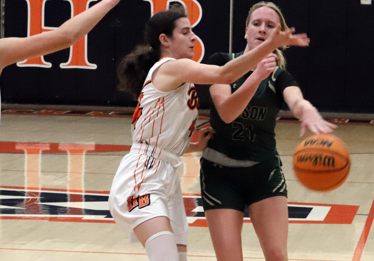 Edison's Taylor Savage (21) dribbles under pressure from Huntington Beach's Isobel Melitas on Saturday.