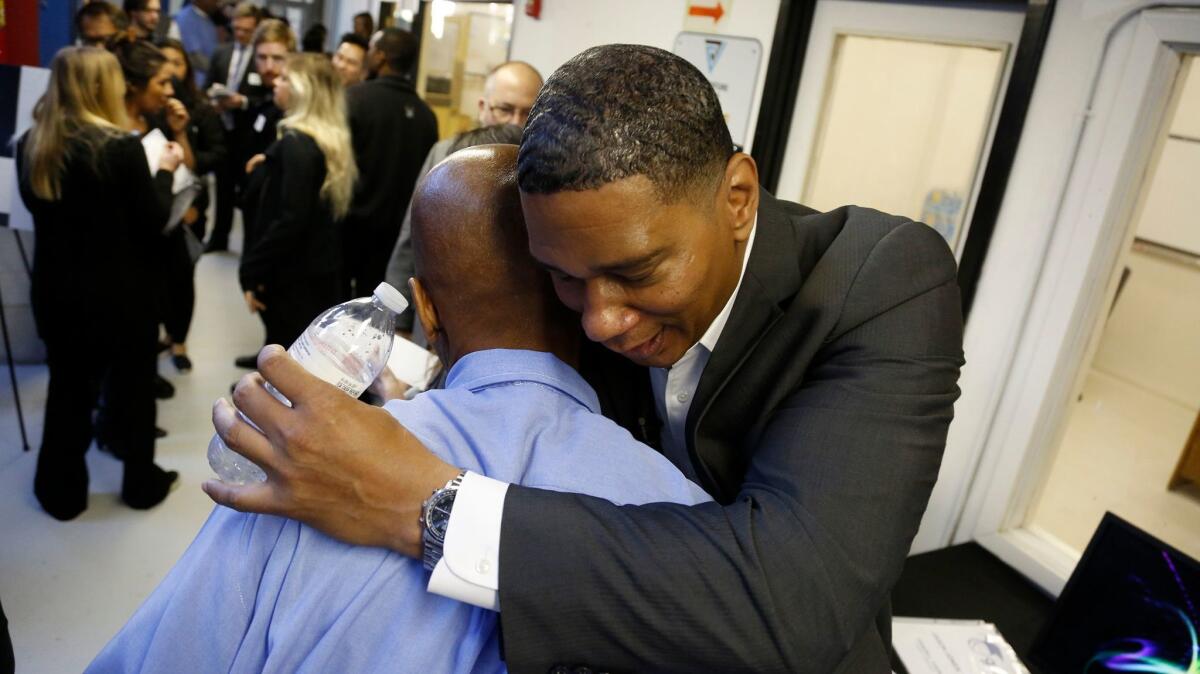Former inmate Chrisfino Kenyatta hugs a San Quentin inmate after a graduation ceremony for the Last Mile Works where he is currently serving on the board of directors.