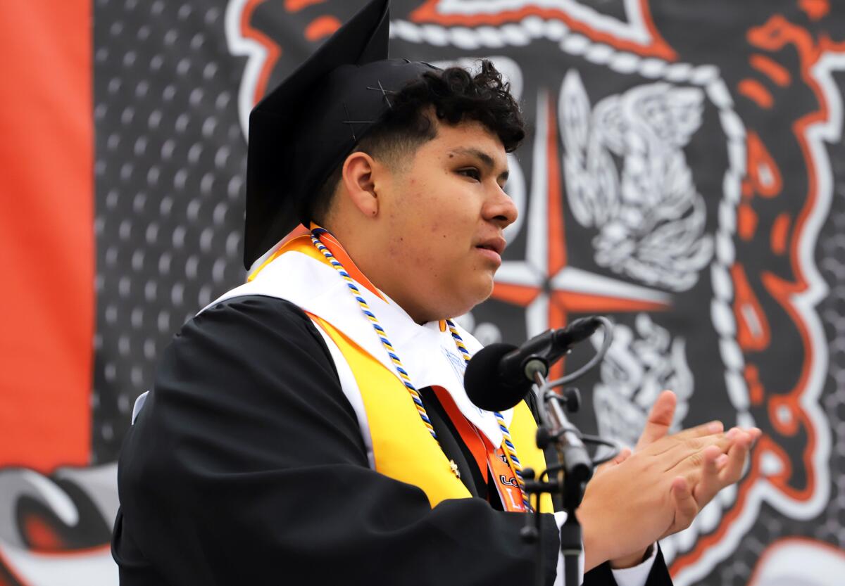Valedictorian Daniel Contreras applauds graduates of Los Amigos High School.