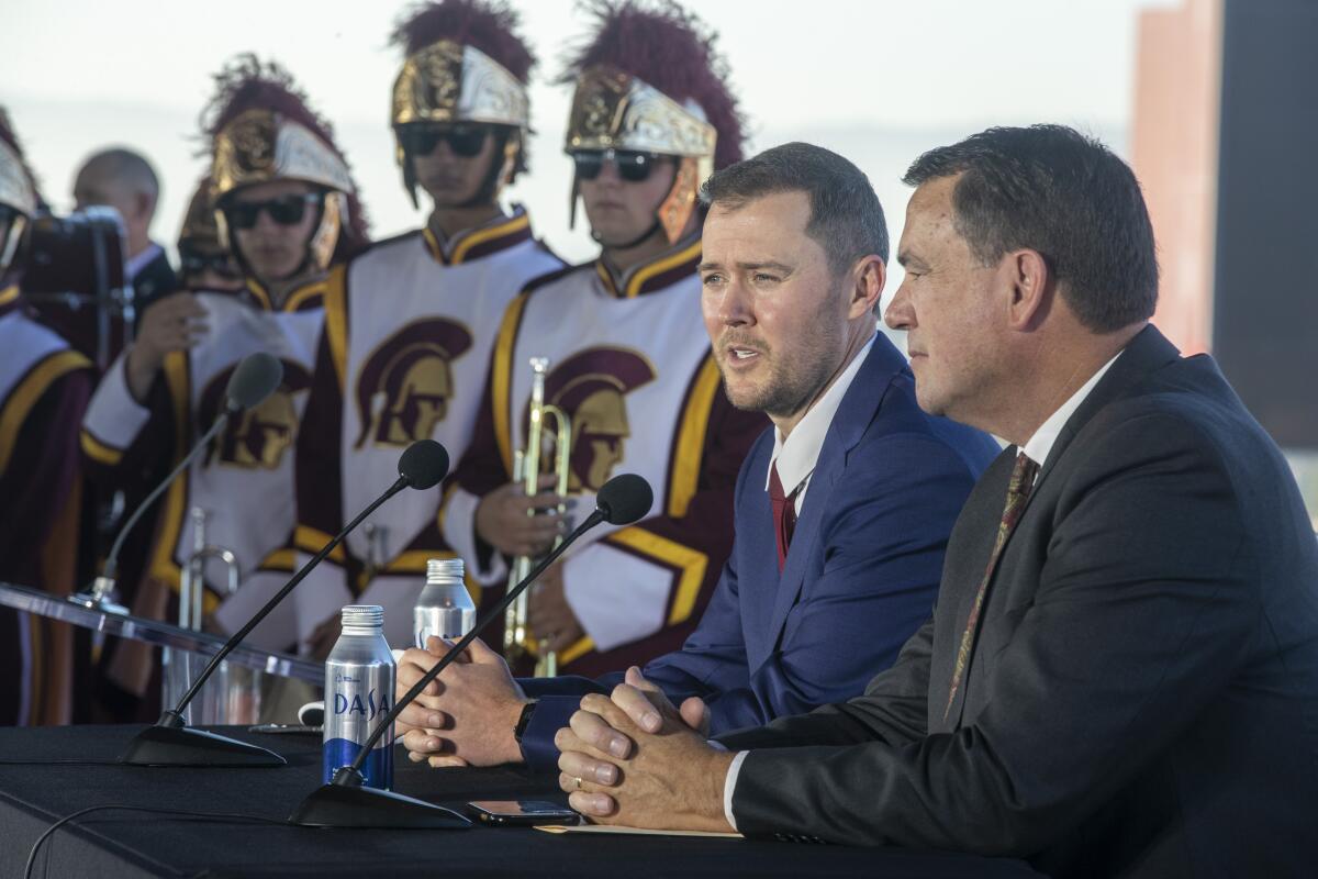 USC football coach Lincoln Riley, left, and USC athletic director Mike Bohn take part in a news conference.