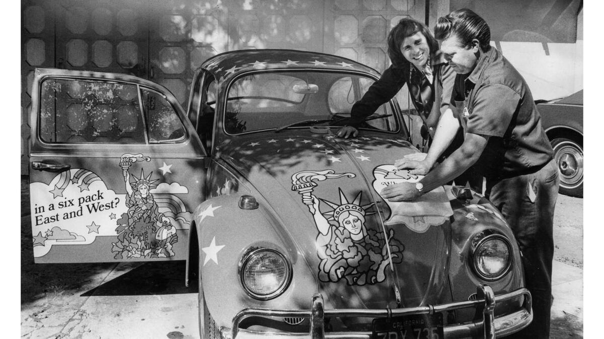 Oct. 25, 1972: Charles E. Bird, left, talks with Donald Brannen as he applies a United Airlines decal to a Volkswagen. Bird, through his Beetleboard advertising company, turned VW bugs into mobile billboards.