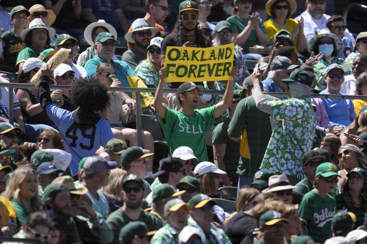 An Oakland Athletics fan holds up a sign protesting the team's planned move to Las Vegas.
