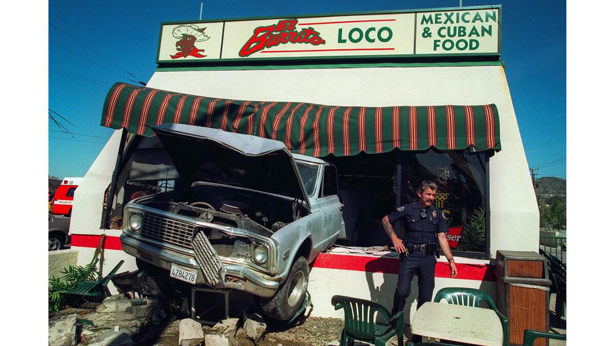 March 5, 1997: Burbank Police Officer Larry Hill looks over the scene where a truck backed through the front of El Burrito Loco at Victory and Burbank boulevards in Burbank.