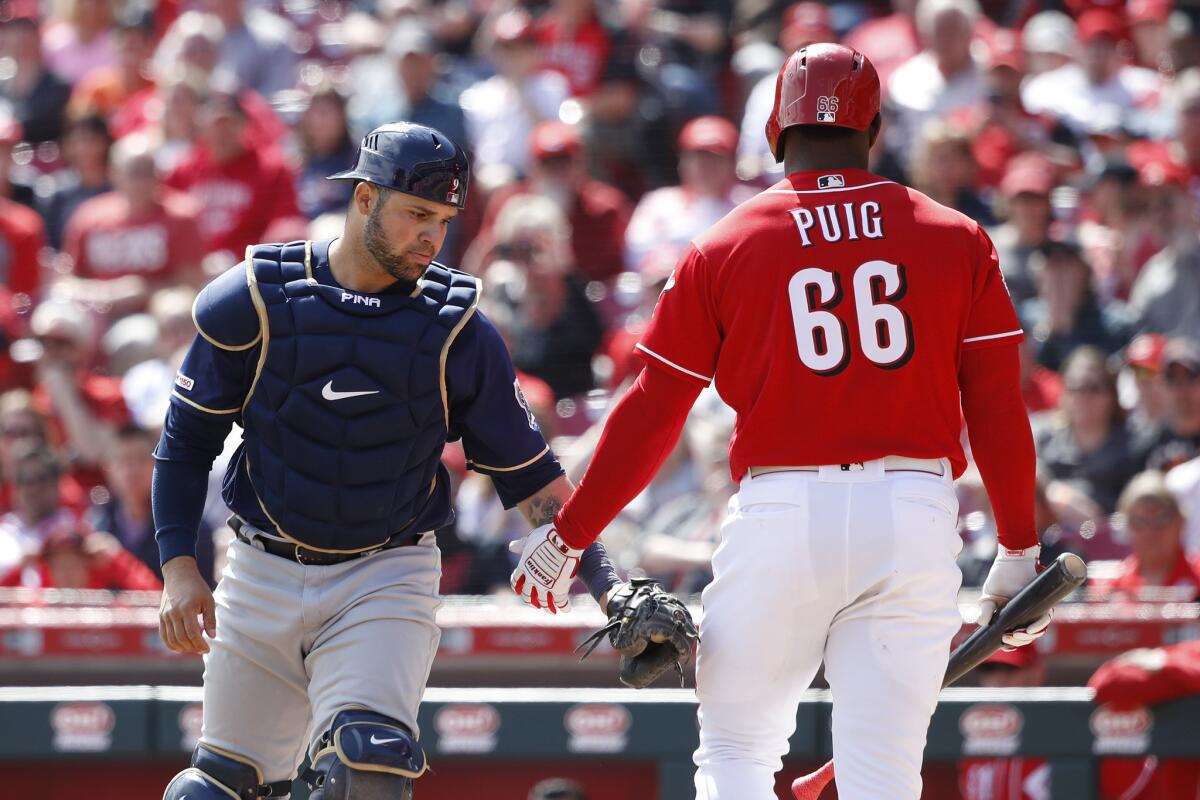 Manny Pina #9 of the Milwaukee Brewers tags Yasiel Puig #66 of the Cincinnati Reds after he struck out to end the eighth inning at Great American Ball Park on April 3, 2019 in Cincinnati, Ohio. The Brewers won 1-0 to complete a three-game sweep.