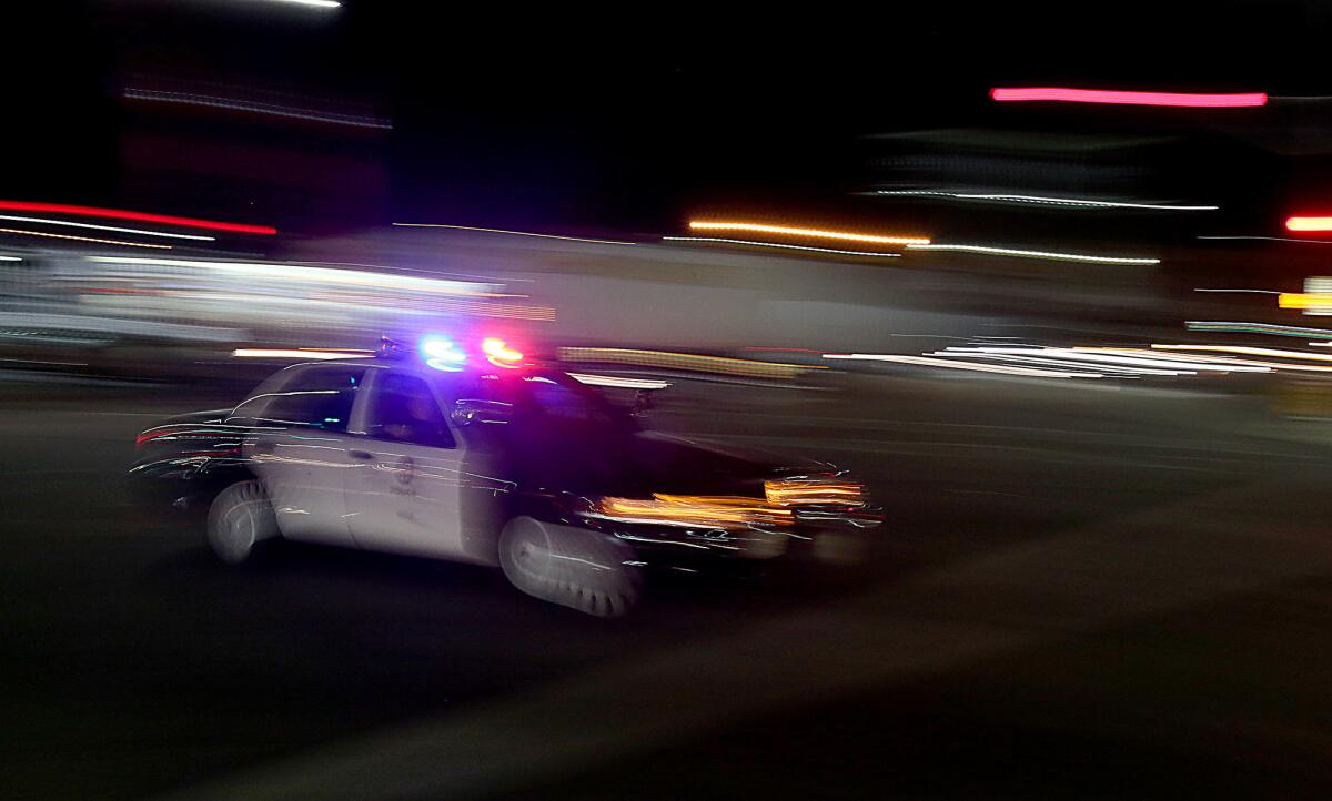 A Los Angeles police patrol car rushes through the intersection of La Brea Avenue and Venice Boulevard in April.