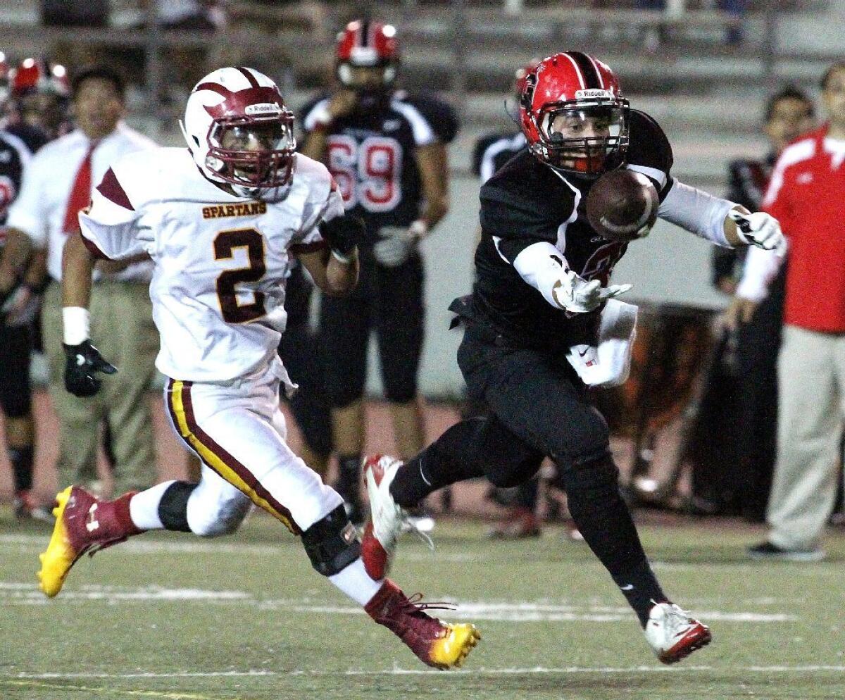 La Cañada High's Jadon Henry, left, tracks down Glendale's Martin Marin, who bobbles a ball twice before coming down with a 57-yard reception. Henry had 102 rushing yards on four carries. Marin had eight receptions for 131 yards.