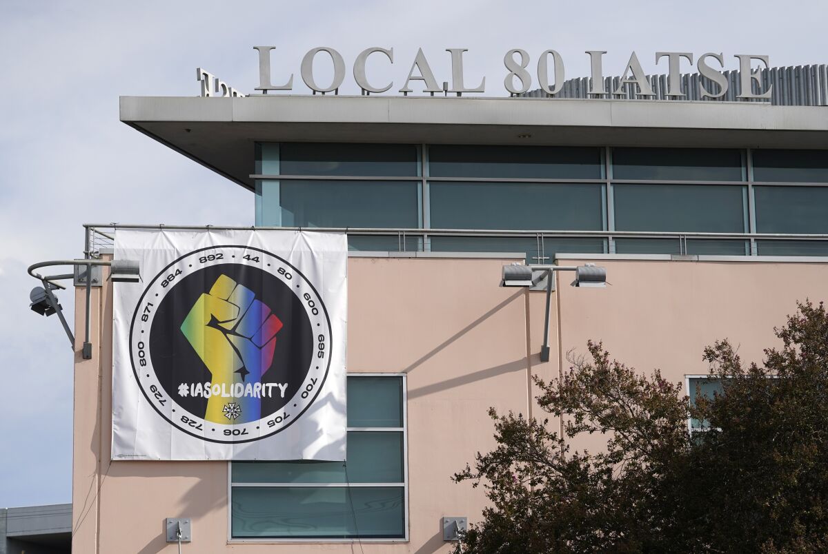 A poster advocating union solidarity hangs from the office building housing The International Alliance of Theatrical Stage Employees Local 80, Monday, Oct. 4, 2021, in Burbank, Calif. The IATSE overwhelmingly voted to authorize a strike for the first time in its 128-year history. (AP Photo/Chris Pizzello)
