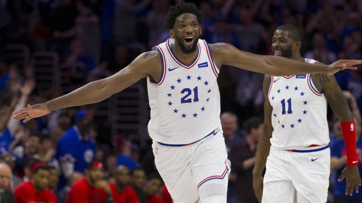 Philadelphia 76ers' Joel Embiid (21) and James Ennis III (11) react after Embiid dunked the ball in the fourth quarter against the Toronto Raptors of Game 3 of the Eastern Conference semifinals on Thursday.