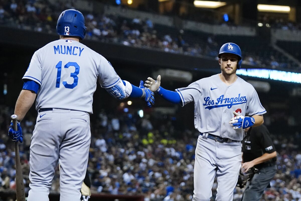 The Dodgers' Trea Turner celebrates his sixth-inning home run with Max Muncy on Sept. 25, 2021.