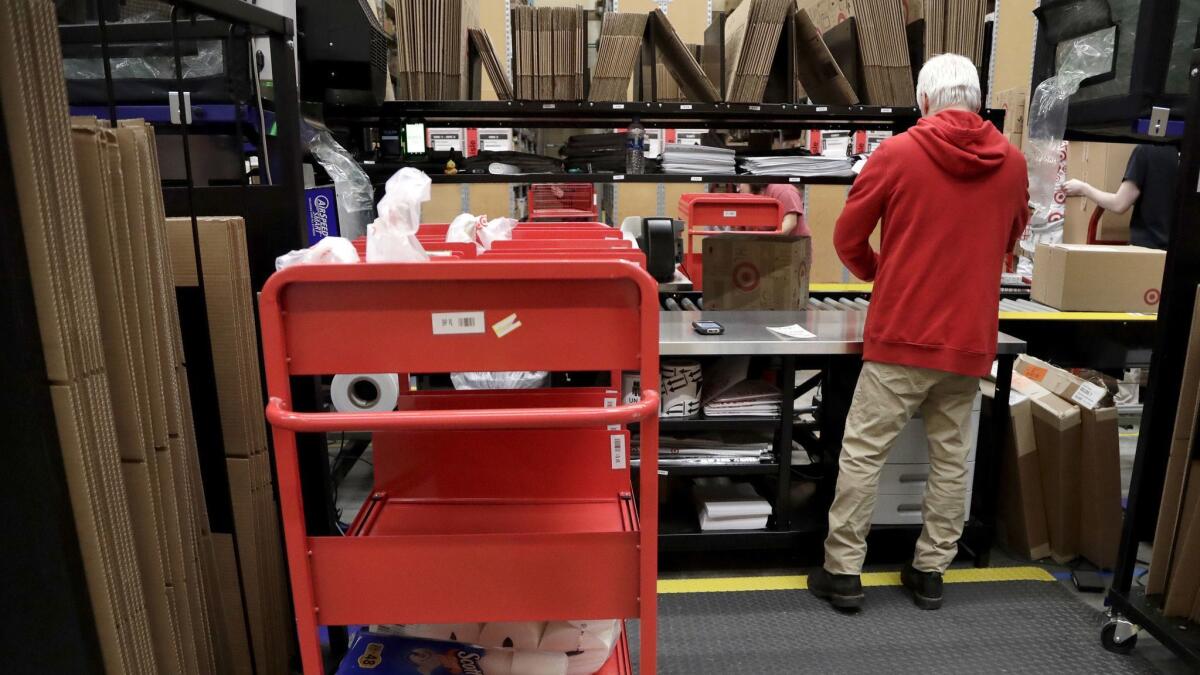 An assembly line worker packages items from an online order to be shipped out of a Target store in Edison, N.J., in November.