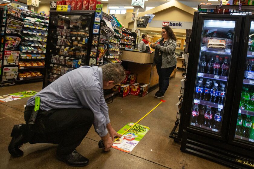 LOS ANGELES, CALIF. - MARCH 22, 2020: Workers at the Ralphs grocery store in Westchester is implementing social distancing guidelines for its customers on Sunday, March 22, 2020 in Los Angeles, Calif.. This Ralphs location is placing social distancing markers every six feet and limiting the number of customers it allows in to shop to help with social distancing due to the Coronavirus pandemic. (Jason Armond / Los Angeles Times)