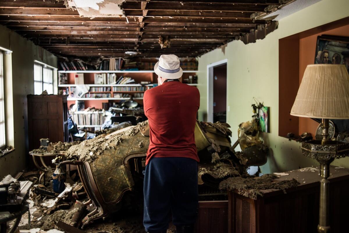 Jim Cheatham of Columbia, S.C., surveys storm damage to his home.